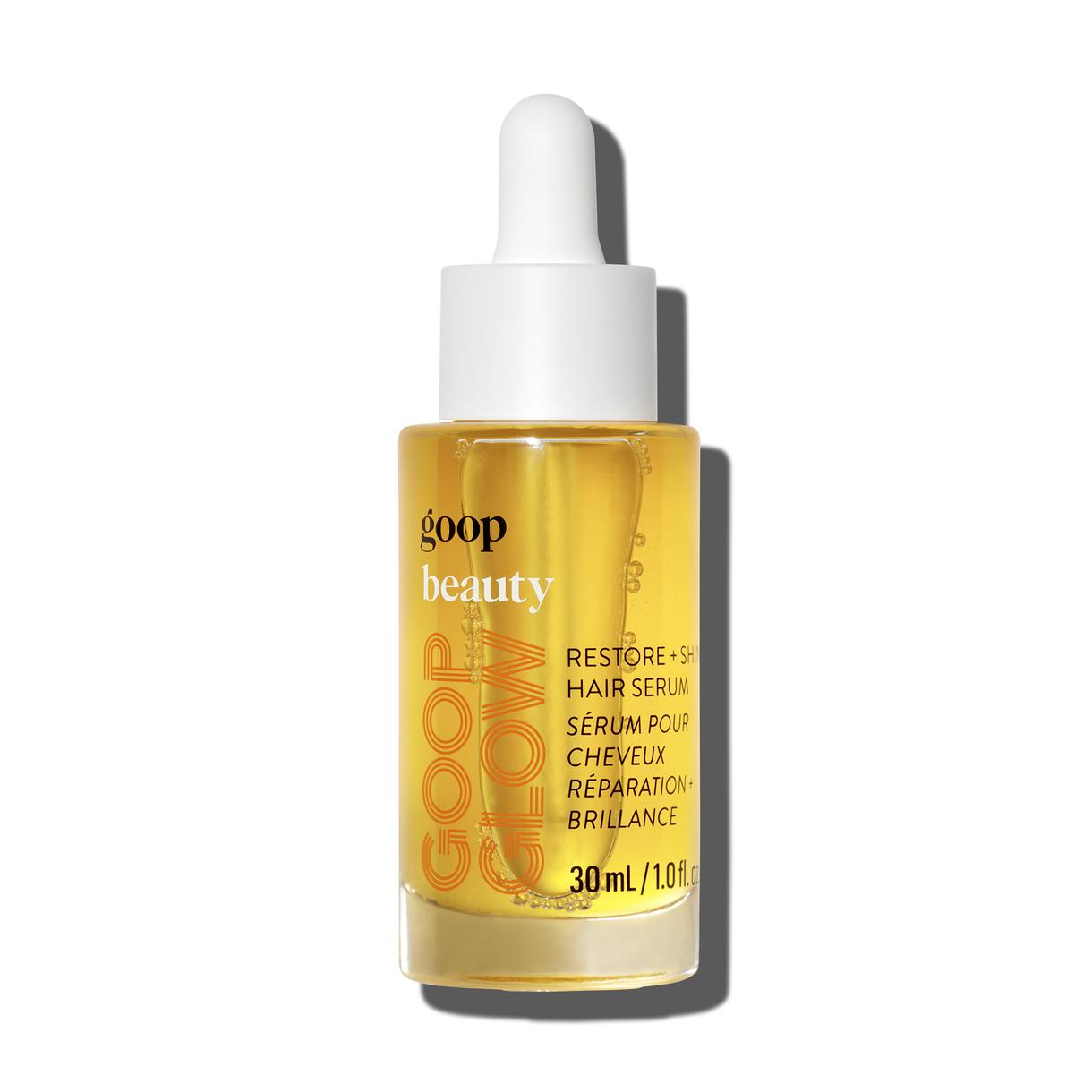 A bottle of goop beauty Restore + Shine Hair Serum with a dropper, against a neutral background.
